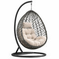 Silla colgante de ratán con cojines beige y estructura de acero